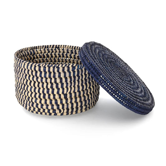A round woven storage basket with a matching lid, featuring a pattern of dark navy blue and natural beige fibers, shown on a clean white background.