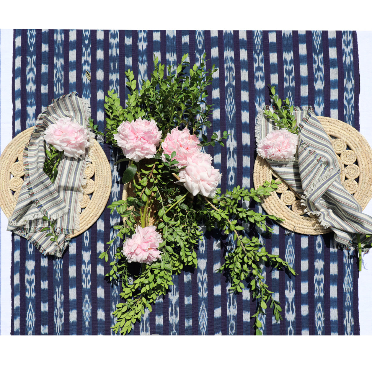 Decorative wreath with pink flowers and green leaves on a blue patterned background