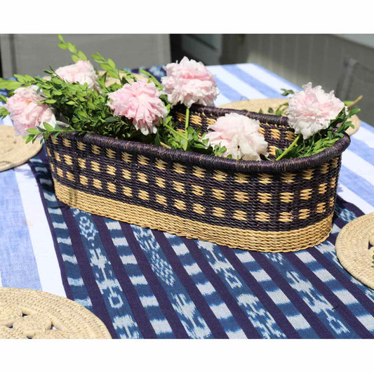 Decorative woven basket with flowers on a tablecloth
