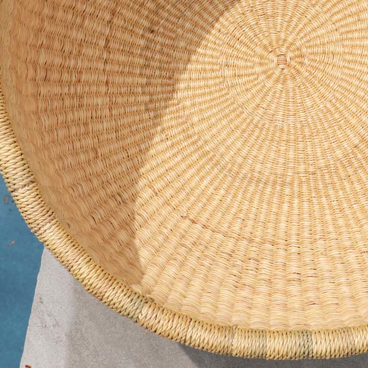 Close-up of a woven basket with a textured surface on a blue and gray background